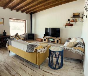 a bedroom with two beds and a flat screen tv at Cantinho da Villa in Portel
