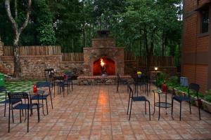 a patio with tables and chairs and a fireplace at Sereno Barn Eco Stay Chikmagalur in Chikmagalūr