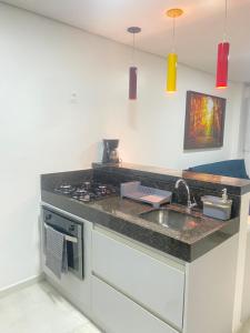 a kitchen with a sink and a counter top at Meireles Compact Apartamento 500m da praia in Fortaleza +4 photos