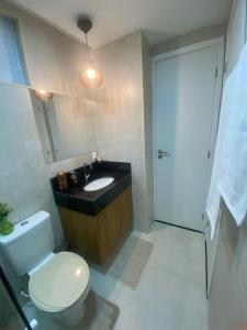 uma casa de banho com um WC, um lavatório e um espelho. em Meireles Compact Apartamento 500m da praia em Fortaleza