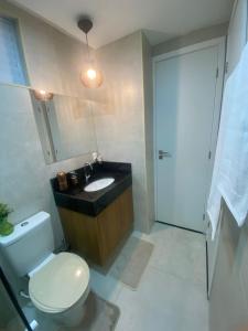a bathroom with a toilet and a sink and a mirror at Meireles Compact Apartamento 500m da praia in Fortaleza