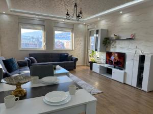 a living room with a couch and a tv at Apartman Ano LUX in Novi Pazar