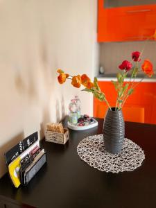 a black table with a vase with flowers on it at "CASA ADELIKA" Appartamento con GARAGE sulla via per il MARE in Grosseto