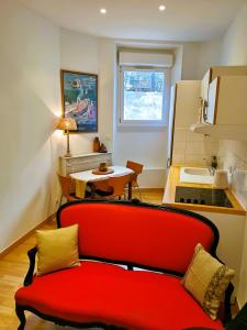 a kitchen with a red couch in front of a table at Appartements 7 Florian in Cannes