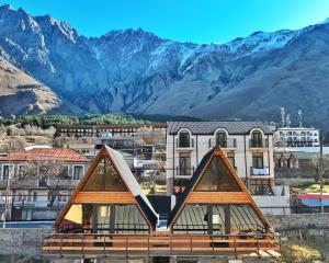 a view of a building with mountains in the background at Luno Cottage in Stepantsminda
