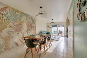 une salle à manger avec une table et des chaises dans l'établissement Maison moderne et piscine commune, à Les Sables-dʼOlonne