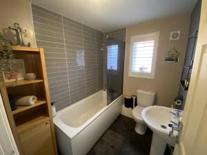 ein Badezimmer mit einer Badewanne, einem WC und einem Waschbecken in der Unterkunft Modern Home Birtley in Birtley