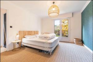 een witte slaapkamer met een bed en een raam bij Vaste villa proche golf du Touquet in Cucq