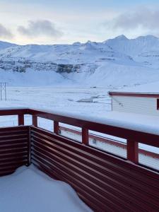 a snow covered balcony with a view of a snow covered field at Kirkjufell Guesthouse and Apartments in Grundarfjordur