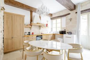 a kitchen with a white table and chairs at Le Clos Des Vosges in Paris