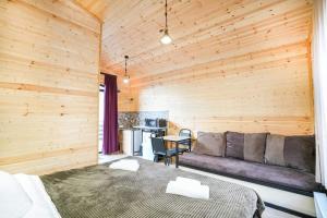 una camera da letto con un letto e un divano in una stanza di SAME Cottage Kazbegi a Kazbegi