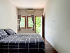 een slaapkamer met een bed en een raam bij Villa Blue Saphire Sanur Mansion in Denpasar