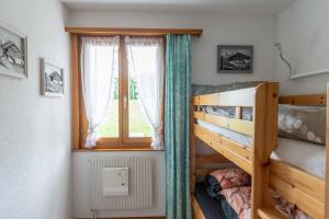 a bedroom with two bunk beds and a window at Pic Chaussy A2 in Les Mosses