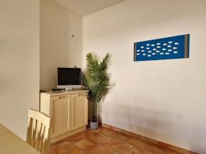 A television and/or entertainment centre at Le Melodie - Appartamenti con spazi esterni privati a Sos Alinos