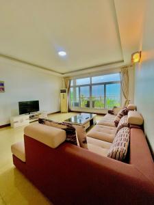 ein großes Wohnzimmer mit Sofas und einem TV in der Unterkunft Arrabella Ocean View Home in Daressalam
