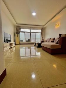 Sala de estar amplia con cama y TV en Arrabella Ocean View Home, en Dar es Salaam