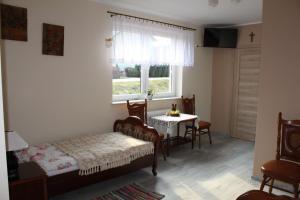 Schlafzimmer mit einem Bett, einem Tisch und einem Fenster in der Unterkunft Agroturystyka Za Dębem in Łagów