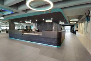 a lobby with a counter in the middle of a building at VitaLounge Sports & Spa Hotel in Gelsenkirchen