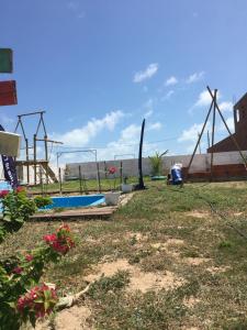ein Hof mit Pool und ein paar Blumen im Gras in der Unterkunft Chale Casa Verde in Aracati