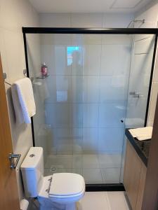 e bagno con servizi igienici e doccia in vetro. di Makia Beach Experience - D 202 a Porto De Galinhas