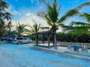 a van parked next to a parking lot with a tent and a table at Airport Kota Bharu Homestay & Riverview Inn in Kota Bharu