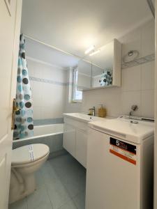 Baño blanco con lavabo y aseo en Gtrip Apartment Syggrou Fix - 338 en Atenas