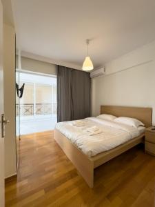 1 dormitorio con 1 cama grande con sábanas blancas en Gtrip Apartment Syggrou Fix - 338 en Atenas