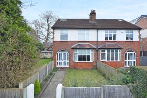 a brick house with a fence in front of it at Hale View by YourStays in Altrincham