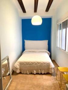 a bedroom with a blue wall and a bed at Bonito y elegante apartamento en Valencia Centro in Valencia
