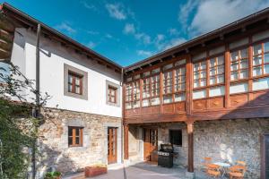 Una vista exterior de un edificio con vigas de madera. en LA CASA DE LA RIBA, en Luanco
