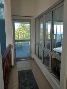 um quarto com 2 janelas grandes e uma varanda em Indaba Manor Guesthouse em Port Edward