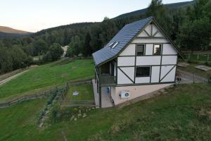 a house on top of a green field at Apartamenty z widokiem in Świeradów-Zdrój