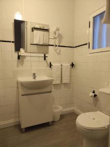 a white bathroom with a toilet and a sink at Hotel Boavista - Vintage House in Monfortinho