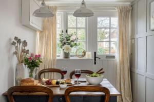 a dining room with a table with food and glasses of wine at Tudor Rose Cottage in Stourpaine