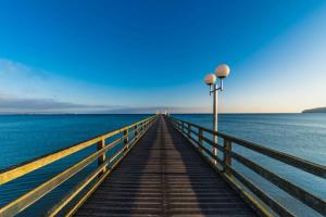 a wooden pier with two lights on the water at Ferienhaus Ivory in Binz