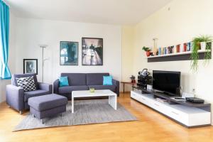 ein Wohnzimmer mit einem Sofa und einem TV in der Unterkunft Ferienwohnung 10 Haus Metropol in Binz