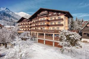 um hotel nas montanhas com neve no chão em Hotel Alpina - Thermenhotels Gastein em Bad Hofgastein