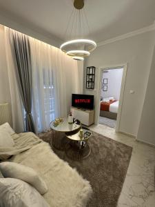 ein Schlafzimmer mit einem Bett und einem Tisch in einem Zimmer in der Unterkunft Psimithefto Luxury Apartments in Thessaloniki
