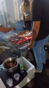une personne debout à côté d'une cuisinière avec de la nourriture dans l'établissement Airport Kota Bharu Homestay & Riverview Inn, à Kota Bharu