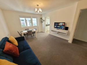 un soggiorno con divano blu e TV di Midland Close Bungalow - With separate office space by Catchpole Stays a Colchester