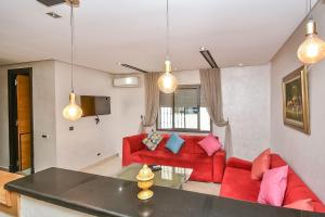 sala de estar con muebles de color rojo y luces colgantes en Sunny Modern 1BR in Belvedere en Casablanca
