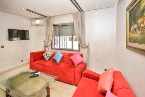 sala de estar con sofá rojo y mesa en Sunny Modern 1BR in Belvedere en Casablanca