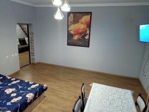 1 dormitorio con 1 cama, 1 mesa y 1 pintura en Aris, en Almaty