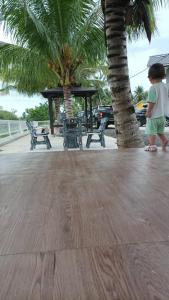 a young child standing on a sidewalk near a tree at Airport Kota Bharu Homestay & Riverview Inn in Kota Bharu