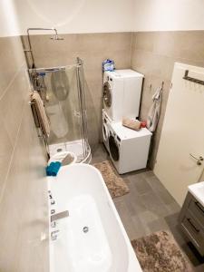 a bathroom with a tub and a washing machine at Traumhaus mit Whirlpool am Schwarzwaldrand in Pforzheim