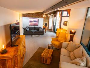 a living room with a couch and a tv at Traumhaus mit Whirlpool am Schwarzwaldrand in Pforzheim