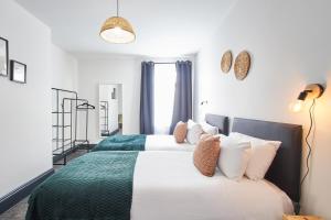 two beds in a room with white and green at Host & Stay - North Shore Cottage in Newbiggin-by-the-Sea