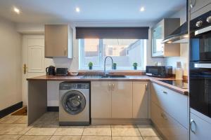 a kitchen with a washing machine and a sink at Host & Stay - North Shore Cottage in Newbiggin-by-the-Sea +10 photos