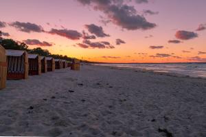 ビンツにあるVilla Sireneの夕日のビーチ小屋が並ぶビーチ