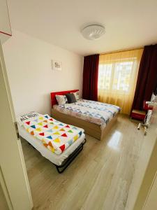 ein Schlafzimmer mit zwei Betten und einem Fenster in der Unterkunft Grandis Residence in Braşov